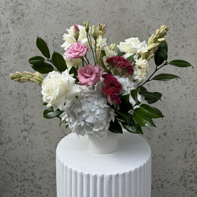 Colourful flowers bouquet from Herbivore florals with purple dahlias and roses in a grey vase