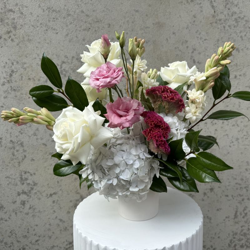 Colourful flowers bouquet from Herbivore florals with purple dahlias and white roses in a grey vase