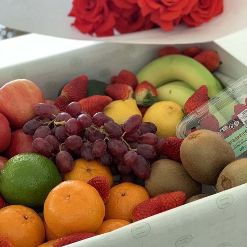 Presentation box filled with fresh fruit tied off in a Herbivore ribbon