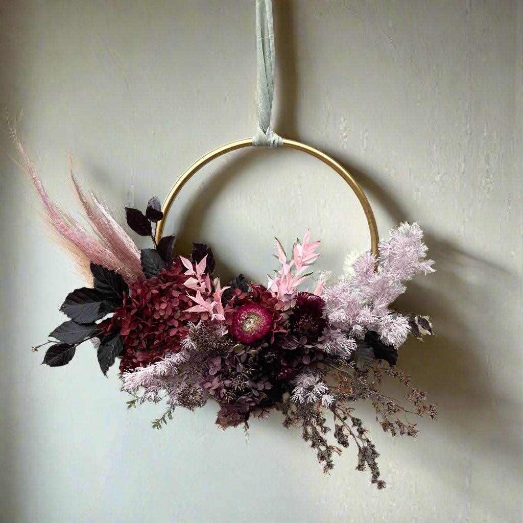 Small decorative wreath with dried preserved pink and red hydrangea