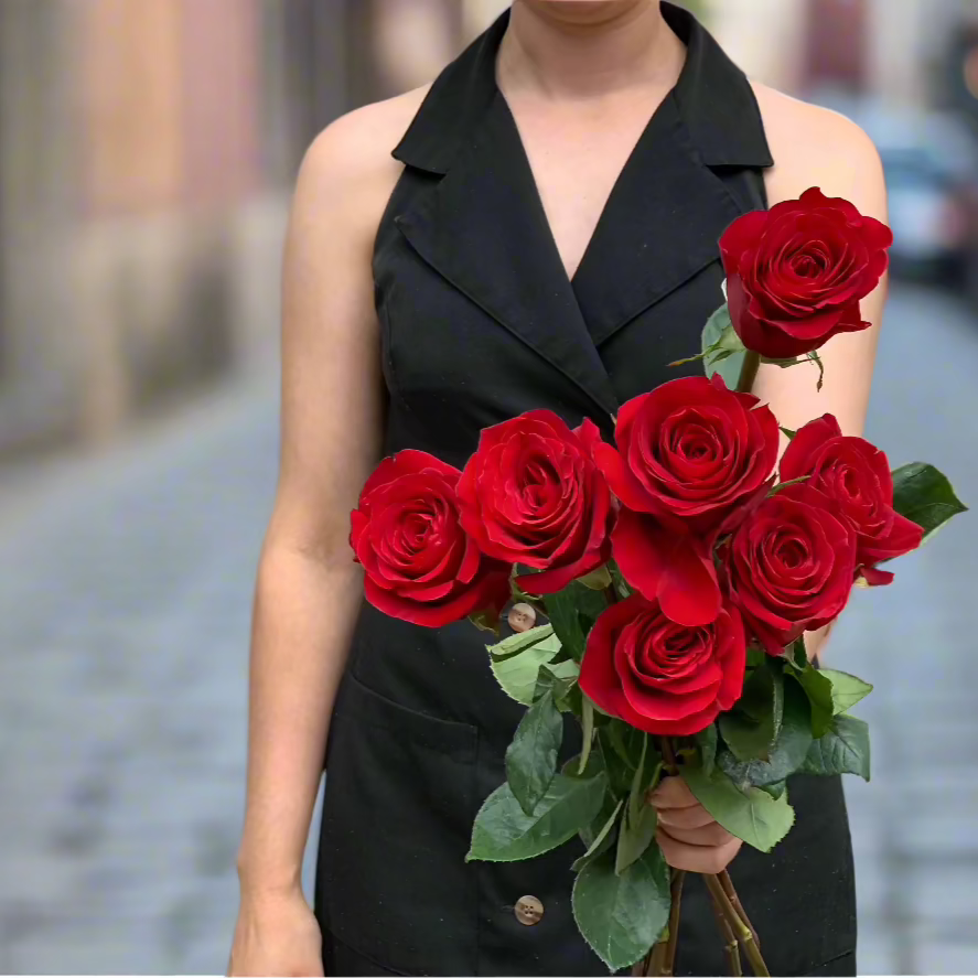 Large bunch of a dozen red roses held by one of Herbivore's Florists