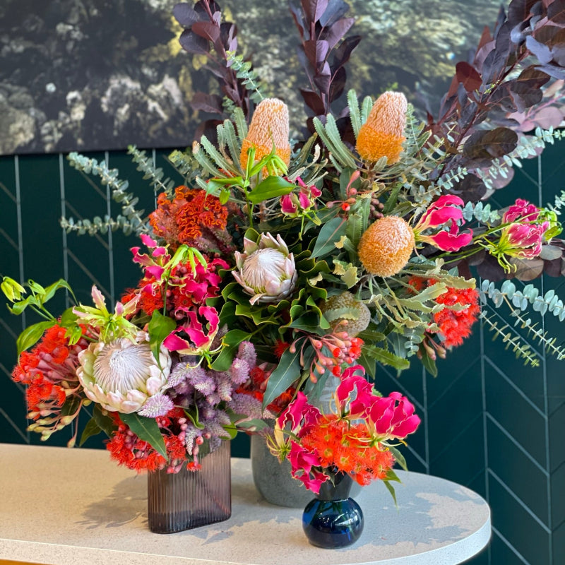 Colourful corporate flower arrangement with natives and orchids