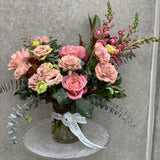 Small pastel arrangement with pink roses and green foliage 