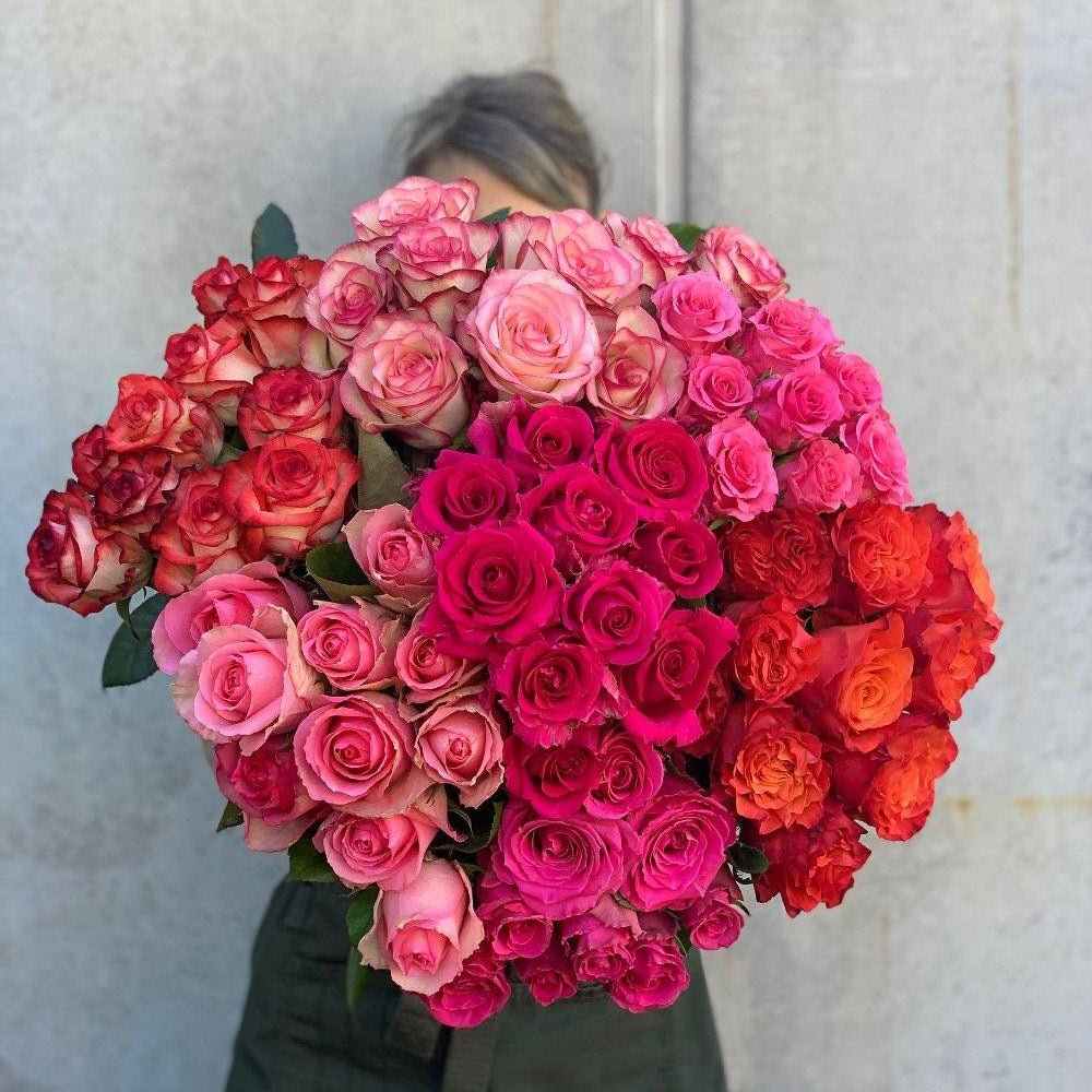 A vibrant bouquet of fresh roses in shades of pink, red, and orange, perfect for gift giving or celebrations