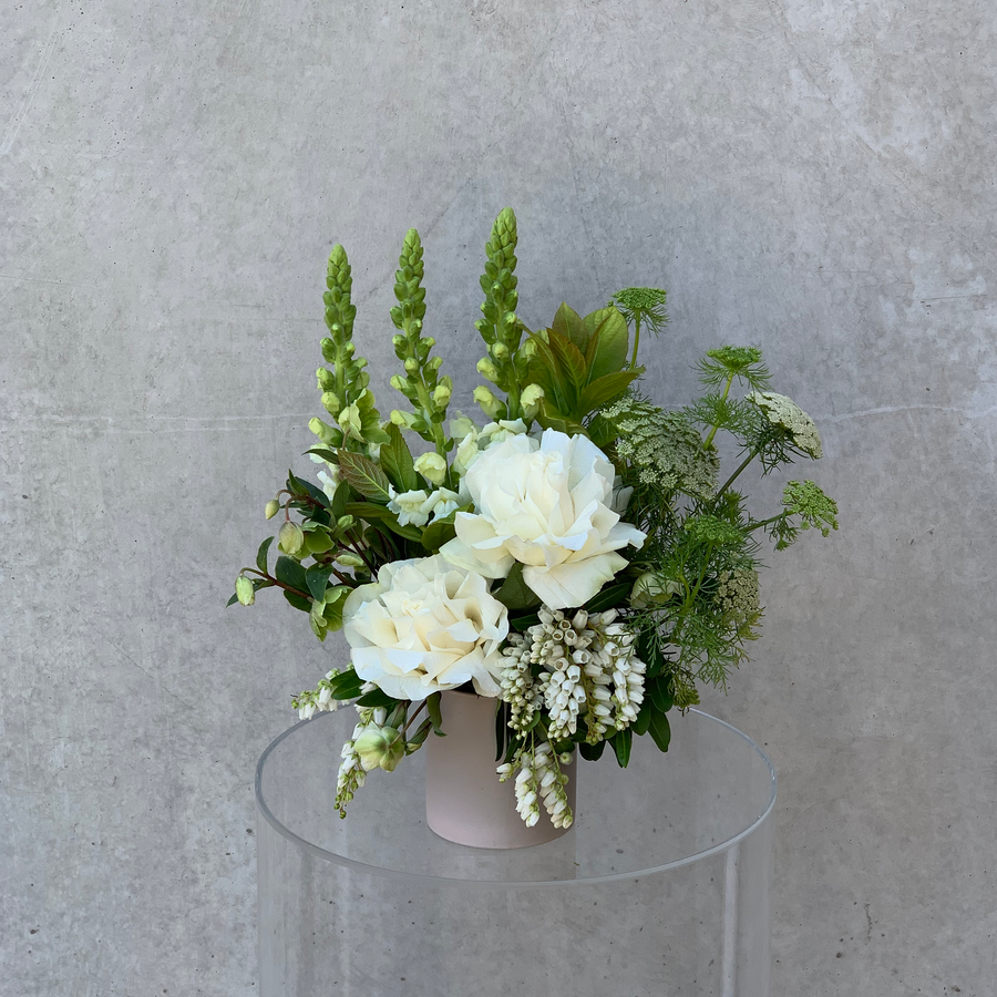 Small vase arrangement featuring assorted white & green toned flowers