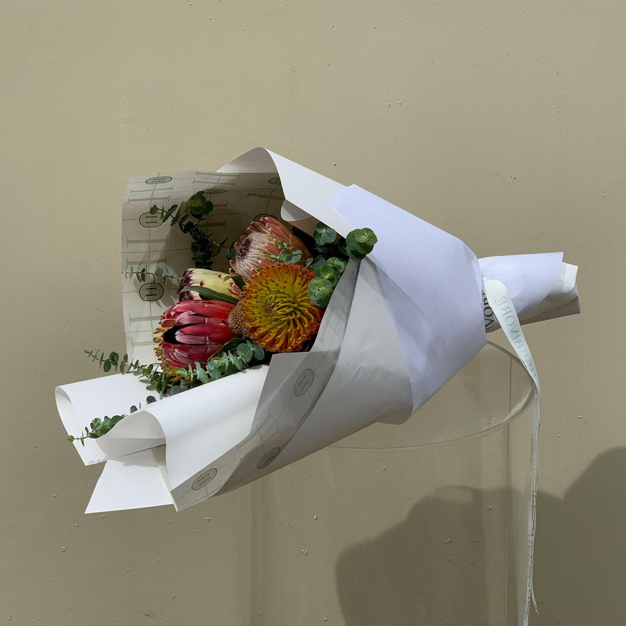 Bouquet of assorted protea flowers gift wrapped.